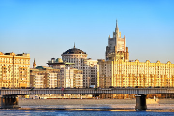 Wall Mural - Classic moscow city russia architecture landmark old stalin empire style building on river embankment with british embassy ministry of foreign affairs against sunset sky background. Street wide view