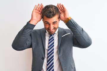 Wall Mural - Young handsome business man wearing suit and tie over isolated background Doing bunny ears gesture with hands palms looking cynical and skeptical. Easter rabbit concept.