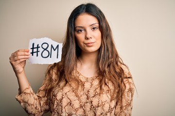 Young beautiful brunette woman celebrating 8th march womens day over white background with a confident expression on smart face thinking serious