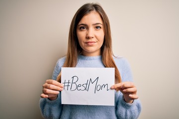 Wall Mural - Young beautiful woman holding paper with best mom message celebrating mothers day with a confident expression on smart face thinking serious