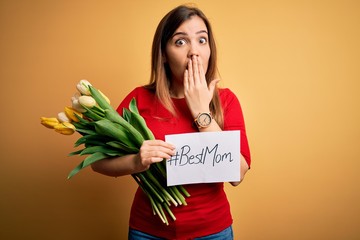 Sticker - Beautiful woman holding paper with best mom message and tulips celebrating mothers day cover mouth with hand shocked with shame for mistake, expression of fear, scared in silence, secret concept