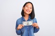 © Krakenimages.com - Young beautiful chinese woman holding one dollar standing over isolated white background with a happy face standing and smiling with a confident smile showing teeth
