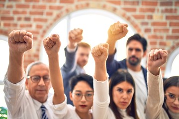 Group of business workers standing with fists up at the office