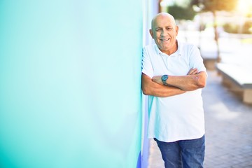 Wall Mural - senior handsome man smiling happy and confident. leaning on the wall with smile on face at town stre