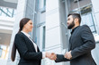 © pressmaster - Below view of smiling lady handshaking with new business partner while greeting him in office