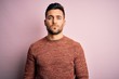 © Krakenimages.com - Young handsome man wearing casual sweater standing over isolated pink background with serious expression on face. Simple and natural looking at the camera.