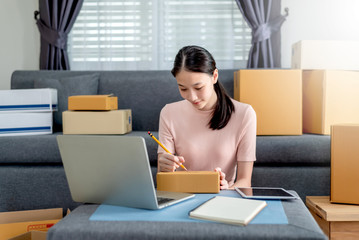 Wall Mural - Happy beautiful girl who works at home About Online Business, Prepare goods to customers.