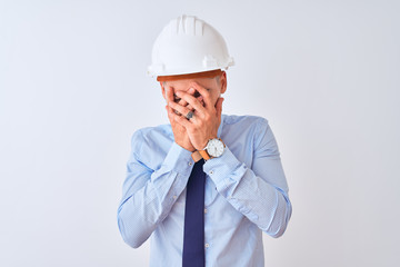 Wall Mural - Young business man wearing contractor safety helmet over isolated background with sad expression covering face with hands while crying. Depression concept.