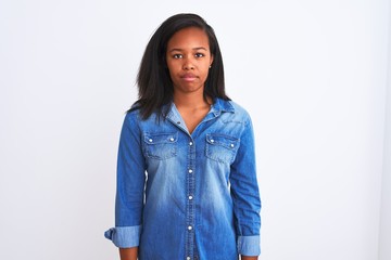 Beautiful young african american woman wearing denim jacket over isolated background Relaxed with serious expression on face. Simple and natural looking at the camera.