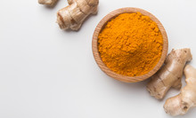 Turmeric Powder In A Wooden Bowl And Fresh Turmeric Root