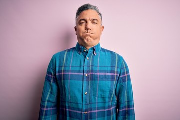 Poster - Middle age handsome grey-haired man wearing casual shirt over isolated pink background puffing cheeks with funny face. Mouth inflated with air, crazy expression.