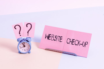 Fototapete - Word writing text Website Check Up. Business photo showcasing an examination of a website to see if something is in order Mini size alarm clock beside a Paper sheet placed tilted on pastel backdrop