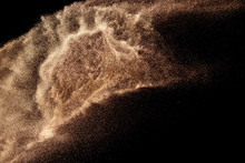 Brown Colored Sand Splash.Dry River Sand Explosion Isolated On Black Background. Abstract Sand Cloud.