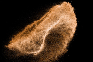 Brown colored sand splash.Dry river sand explosion isolated on black background. Abstract sand cloud.