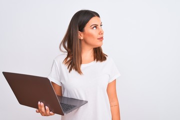 Sticker - Beautiful young woman working using computer laptop over white background looking to side, relax profile pose with natural face and confident smile.