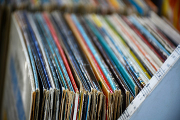 Collection of colorful old used vinyl record lp's with sleeves in storage shelf