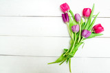 Fototapeta Tulipany - Bunch of red and purple tulips on white wooden background with copy space like postcard on womens day