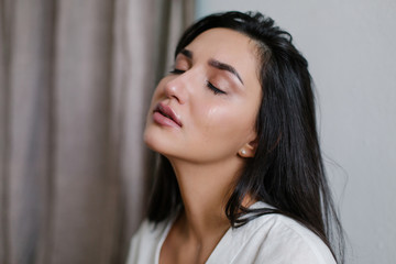 Wall Mural - The girl is crying. Sadness is trouble chagrin depression tragedy loss  concept. Misfortune abuse divorce break off relations. Flowing tear. Emotional portrait of a beautiful caucasian women