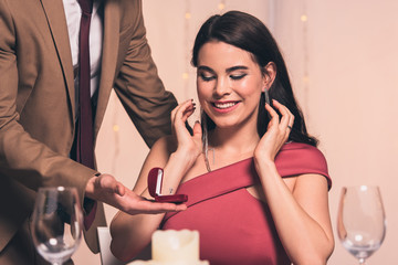 Wall Mural - cropped view of elegant man making marriage proposal to happy girlfriend in restaurant