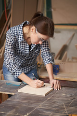 Close up carpenter woman in glasses with tape measure and blackboard