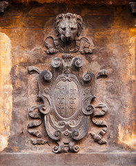 Wall Mural - Old heraldic emblem with lily and St Mark Lion head on a Venice wall