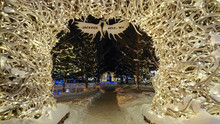 CLOSE UP: Christmas Lights Arc Over A Walkway In A Snowy Park In Jackson Hole.