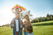 © Svitlana - Love and care. Happy family playing a kite. Outdoor family weekend