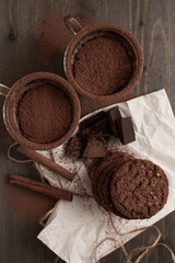 Wall Mural - Two cups of hot chocolate with cinnamon on a wooden table with oatmeal cookies and chocolate