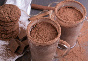 Wall Mural - Two cups of hot chocolate on a wooden table with oatmeal cookies and chocolate