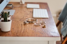 Woman's Silver Jewellery On A Desk Next To A Computer