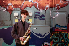 High School Jazz Band Musician Posing With Saxophone By Graffiti
