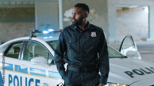 Fotomural Attractive african american young man cops stand near patrol car look at camera
