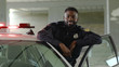 Smiling african american young man cops stand near patrol car look at camera enforcement happy officer police uniform auto safety security communication control policeman close up slow motion