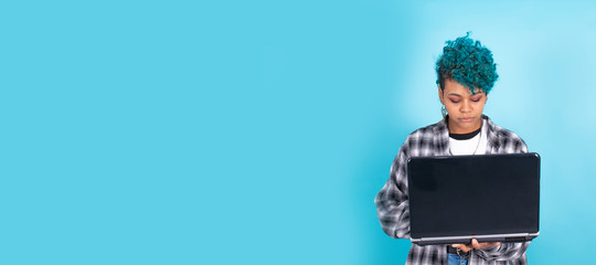 afro american girl with laptop computer isolated on blue background