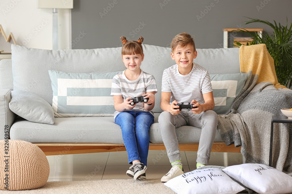 Little children playing video games at home