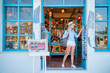 Travel and shopping. Young traveling woman with backpacks choose postcards in souvenir shop in Greece.