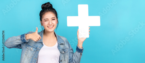 Fotomural Banner of asian woman smiling, showing plus or add sign and thumb up on blue background