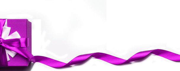 Purple gift box with bow and ribbon on a white background, isolated image