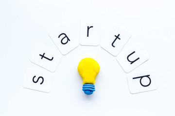 Startup concept with bulb icon on white background top-down