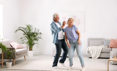 Wall Mural - Happy mature couple dancing together in living room