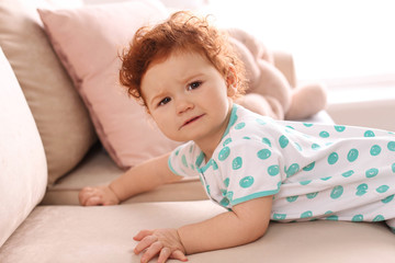 Wall Mural - Portrait of cute little child on sofa at home