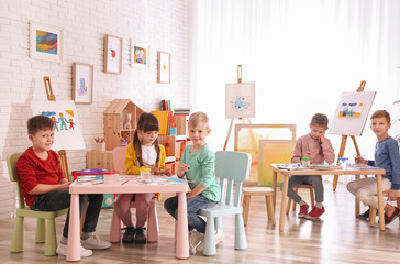 Sticker - Cute little children painting at table in room