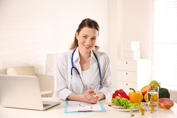 Poster - Nutritionist with clipboard and laptop at desk in office