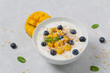 Breakfast smoothie bowl with mango, granola, yogurt, blueberries and Chia seeds.