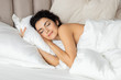 © deniskomarov - Beautiful woman sleeping on white pillow under blanket in cozy home bedroom.