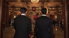 Epic slow motion shot of two men in suits entering casino hall in Monte Carlo, Monaco