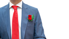 Romantic Businessman In Blue Suit, Red Tie, White Shirt With Red Rose In Pocket Isolated On White Background. Copy Space. Real Gentleman Dress Code. Greeting For Woman’s Day, 8 March, 14 February