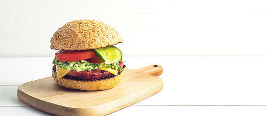 Vegetarian Burger with beetroot cutlet and pesto sauce, cucumber and tomato.