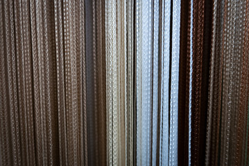 Sticker - Textile strings and ropes hangs in a fabric shop. Abstract background.