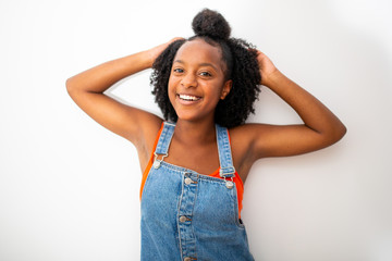 Wall Mural - happy african girl laughing with hands behind head against white background